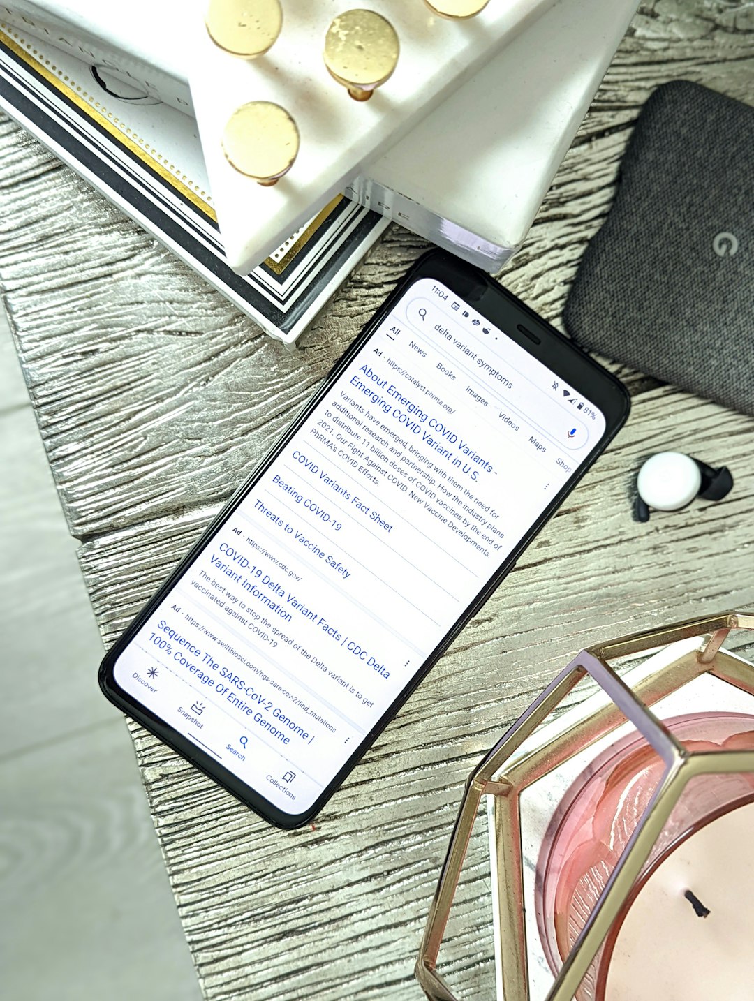 Smartphone showing a dosing tracker app next to peptide vials and a syringe on a desk